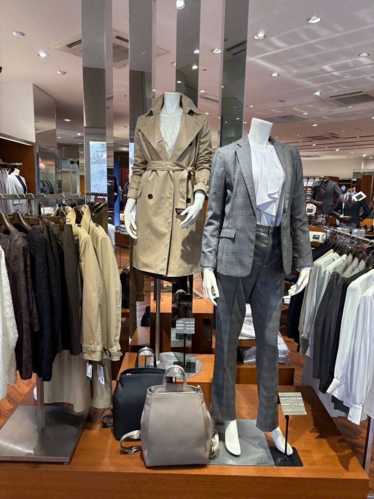 スーツセレクトアスナル金山 レディースコーナー トレンチコート・セットアップの2体のマネキンが陳列されている