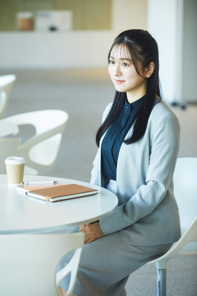 ライトグレーのノーカラースーツを着た女性の写真